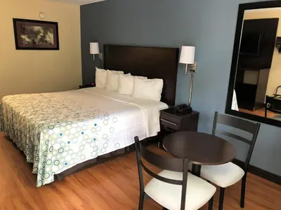 a hotel room with a bed and a table and chairs at HomeTowne Studios by Red Roof Bordentown - McGuire AFB in Bordentown