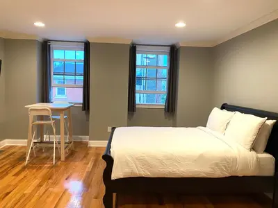 a bedroom with a bed and a table and two windows at AF Stays - Philadelphia 1212 Mt Vernon St in Philadelphia