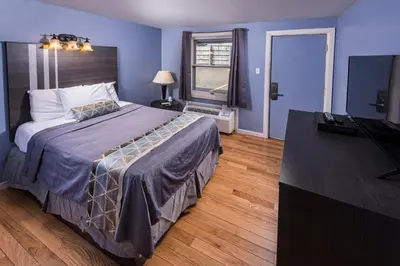 a bedroom with a bed and a flat screen tv at Sunrise Inn Hershey in Hershey