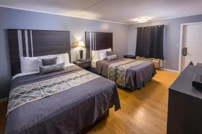 a hotel room with two beds and a television at Sunrise Inn Hershey in Hershey