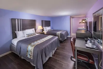 a hotel room with two beds and a desk at Sunrise Inn Hershey in Hershey