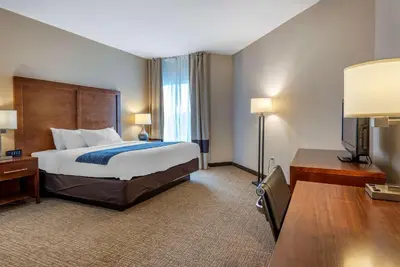a large hotel room with a bed and a desk at Comfort Inn Apalachin - Binghamton W Route 17 in Apalachin