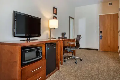 a room with a desk with a television and a chair at Comfort Inn Apalachin - Binghamton W Route 17 in Apalachin