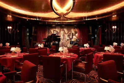 a restaurant with red tables and chairs and a piano at Casa Cipriani New York in New York