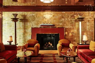 a living room with a fireplace and red couches at Casa Cipriani New York in New York