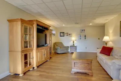 a living room with a couch and a tv at Ski, Swim and Relax Waterfront Haven on Pines Lake! in Pocono Lake