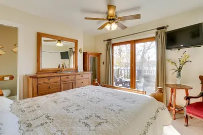 a bedroom with a large bed and a mirror at Ski, Swim and Relax Waterfront Haven on Pines Lake! in Pocono Lake