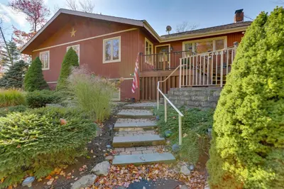 a house with a staircase in front of it at Ski, Swim and Relax Waterfront Haven on Pines Lake! in Pocono Lake