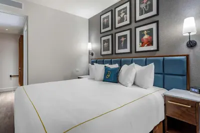 a bedroom with a large white bed with a blue headboard at The Draper New York, Tapestry Collection by Hilton in New York