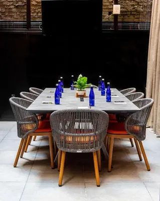 a table with chairs and blue bottles on it at The Draper New York, Tapestry Collection by Hilton in New York