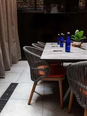 a table with blue bottles on it with chairs at The Draper New York, Tapestry Collection by Hilton in New York