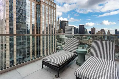 a balcony with two chairs and a view of a city at The Draper New York, Tapestry Collection by Hilton in New York