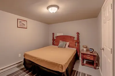 a small bedroom with a bed and a night stand at Luxurious house with largest hot tub & perfect retreat! in Lake Harmony