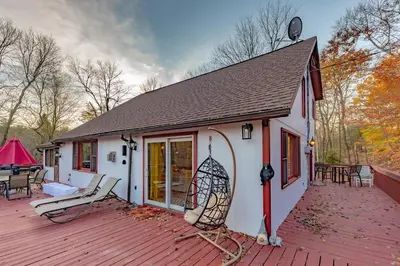 a house on a wooden deck with a patio at Luxurious house with largest hot tub & perfect retreat! in Lake Harmony