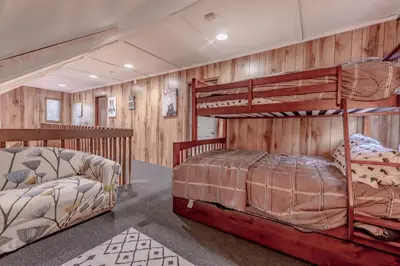 two bunk beds in a room with wooden walls at Luxurious house with largest hot tub & perfect retreat! in Lake Harmony