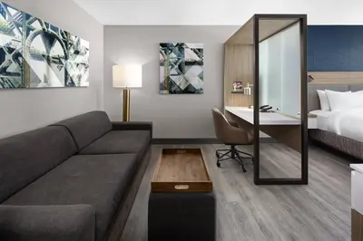 a living room with a couch and a desk in a hotel room at SpringHill Suites by Marriott East Rutherford Meadowlands Carlstadt in Carlstadt