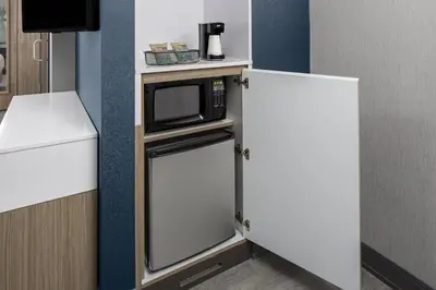 a small kitchen with a microwave and a refrigerator at SpringHill Suites by Marriott East Rutherford Meadowlands Carlstadt in Carlstadt