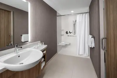 a bathroom with a white sink and a shower at SpringHill Suites by Marriott East Rutherford Meadowlands Carlstadt in Carlstadt