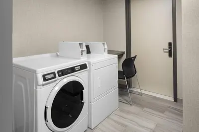 a washing machine with two boxes on top of it at SpringHill Suites by Marriott East Rutherford Meadowlands Carlstadt in Carlstadt