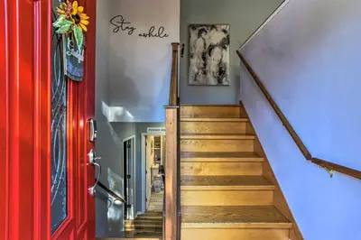a hallway with a red door and a staircase at Hot Tub, Fire Pit and Resort Perks Tobyhanna Home! in Tobyhanna