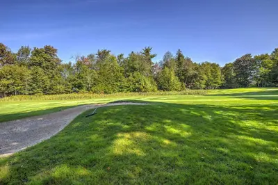 a golf course with a road leading to a green at Hot Tub, Fire Pit and Resort Perks Tobyhanna Home! in Tobyhanna