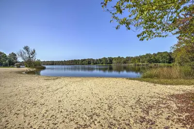 a sandy beach next to a body of water at Hot Tub, Fire Pit and Resort Perks Tobyhanna Home! in Tobyhanna