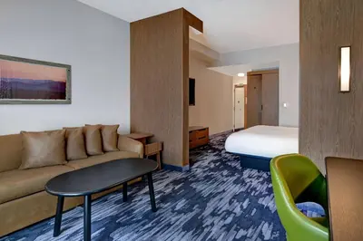 a hotel room with a couch and a bed at Fairfield Inn & Suites by Marriott Selinsgrove in Selinsgrove
