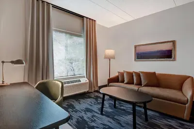 a living room with a couch and a table and a window at Fairfield Inn & Suites by Marriott Selinsgrove in Selinsgrove