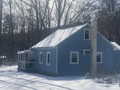 a blue house with snow on the ground at Camelback cottage - on ONE ACRE & near local attractions in Tannersville