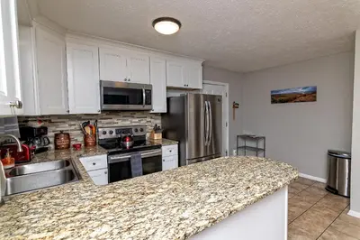 a kitchen with white cabinets and a granite counter top at Camelback Rd Rancher- On ONE ACRE & near attractions in Tannersville