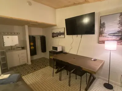a room with a table and a television on the wall at Sussex Motel in Wantage