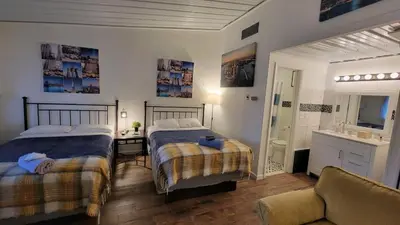 a bedroom with two beds and a sink and a couch at Sussex Motel in Wantage