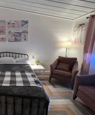 a bedroom with a bed and a chair at Sussex Motel in Wantage
