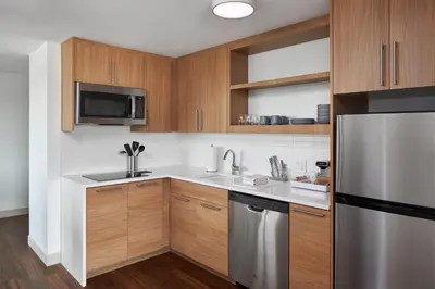 a kitchen with wooden cabinets and a stainless steel refrigerator at Element Valley Forge King of Prussia in King of Prussia