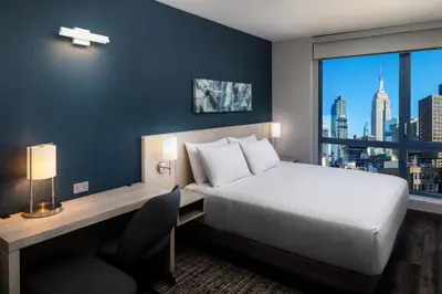 a bedroom with a bed and a desk and a window at Hyatt Place New York Chelsea in New York
