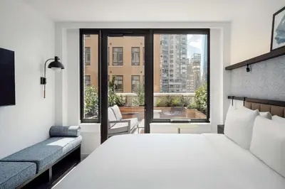 a bedroom with a large white bed and a window at Arlo Midtown in New York