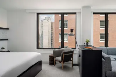 a bedroom with a bed and a desk and a chair at Arlo Midtown in New York