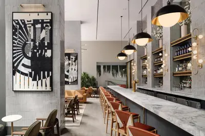 a bar in a restaurant with chairs and tables at Arlo Midtown in New York
