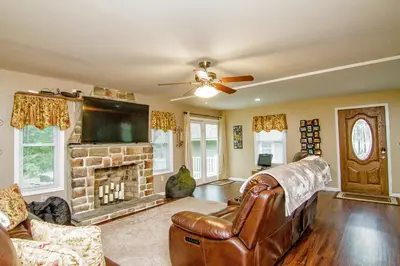 a living room with a couch and a fireplace at Cabin by the Creek with private creek access in Tannersville