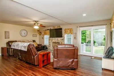 a living room with leather furniture and a fireplace at Cabin by the Creek with private creek access in Tannersville