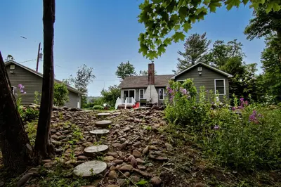 a house with a stone path in front of it at Cabin by the Creek with private creek access in Tannersville