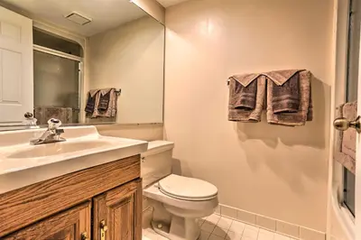 a bathroom with a toilet and a sink and a mirror at On Big Boulder Lake Condo with Community Pools! in Lake Harmony