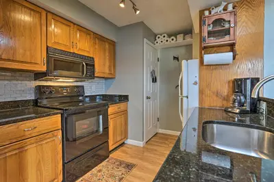 a kitchen with wooden cabinets and stainless steel appliances at On Big Boulder Lake Condo with Community Pools! in Lake Harmony