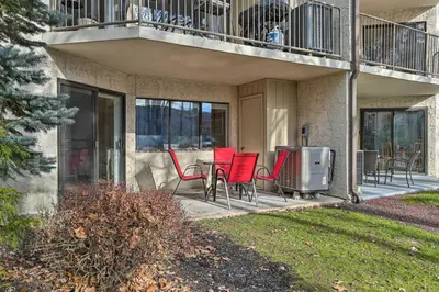 a patio with red chairs and a table on a balcony at On Big Boulder Lake Condo with Community Pools! in Lake Harmony
