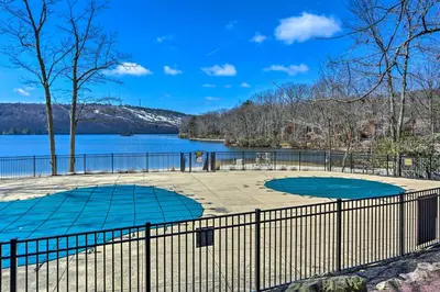 two tennis courts with a lake in the background at On Big Boulder Lake Condo with Community Pools! in Lake Harmony