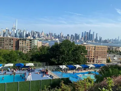 a large swimming pool with a city in the background at Nice 2 bedrooms, Massage Seat, close to New York, THE BEST CHOICE!! in North Bergen