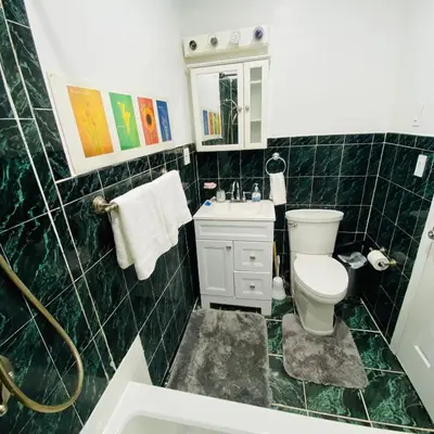 a green tiled bathroom with a toilet and a sink at Nice 2 bedrooms, Massage Seat, close to New York, THE BEST CHOICE!! in North Bergen