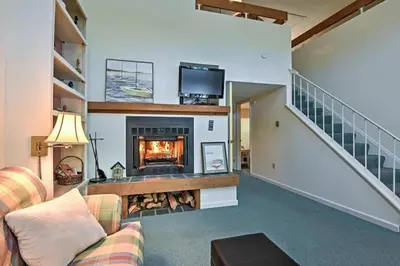 a living room with a fireplace and a staircase at LAKEFRONT Penthouse at Jack Frost Big Boulder in Lake Harmony