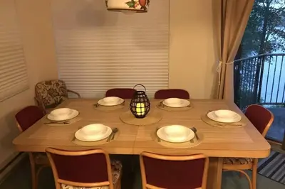 a wooden table with chairs and a lantern on it at LAKEFRONT Penthouse at Jack Frost Big Boulder in Lake Harmony
