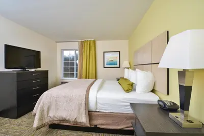 a hotel room with a bed and a television at Candlewood Suites Harrisburg-Hershey by IHG in Harrisburg